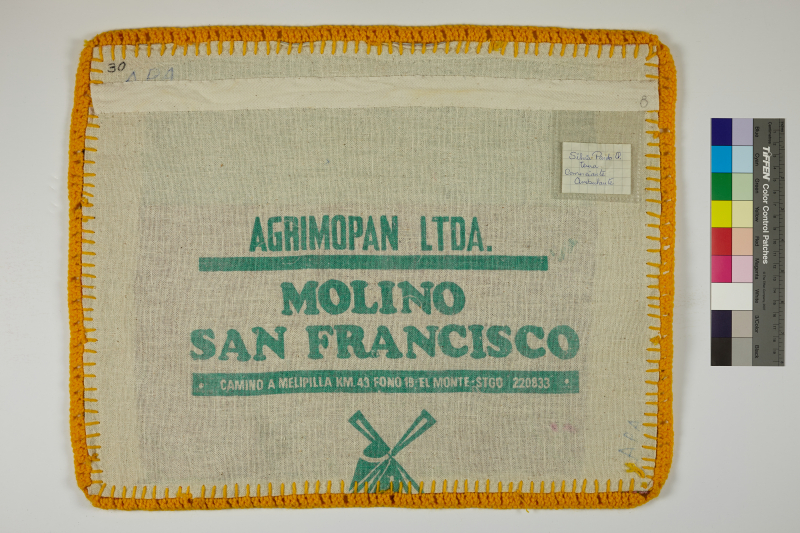 The back of an Arpillera lined with yellow yarn