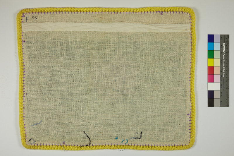 The back of an Arpillera lined with yellow yarn